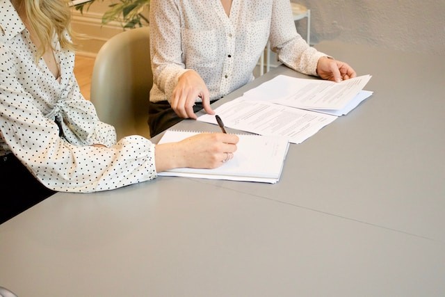 two women work with documents