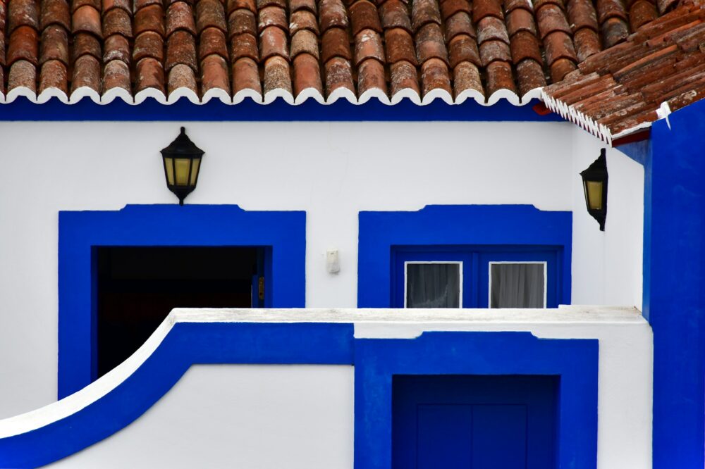 a-white-and-blue-building-with-a-red-roof
