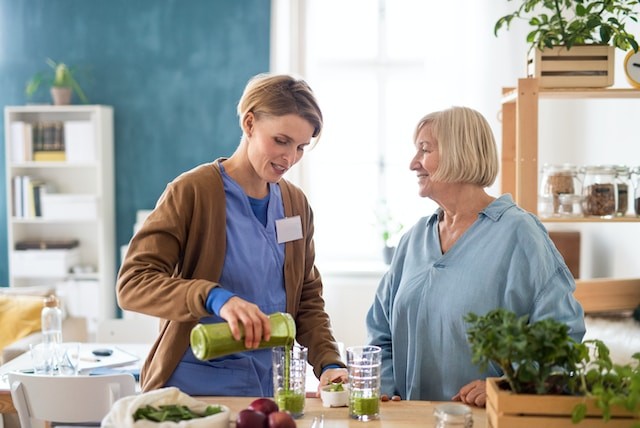 senior woman with caregiver or healthcare worker indoors