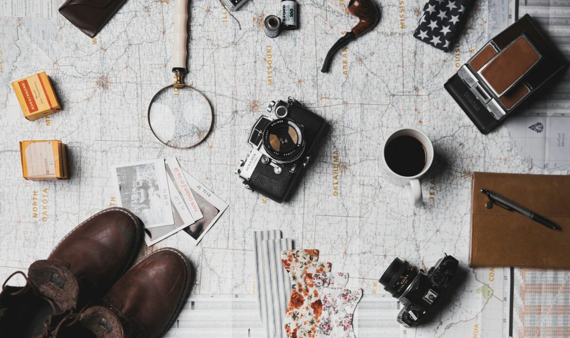 camera, pair of brown shoes, white ceramic mug, grey and black pen, brown smoking pipe