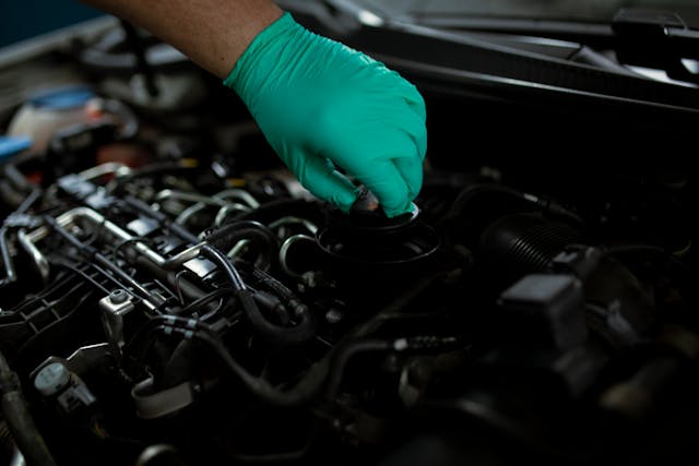 a-mechanic-opening-the-oil-filler-cap-of-a-car-engine